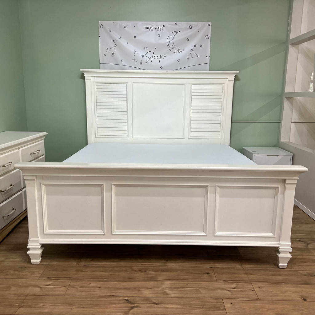 White cottage-style king bed frame with louvered headboard